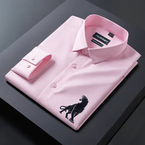Pink dress shirt with a black embroidered lion design on a dark surface