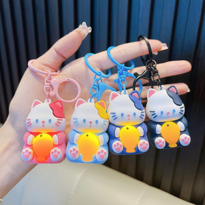 A Hand Holding Four Different Colored Light-Up Cat Keychains with a Yellow Fish - Tinyminymo