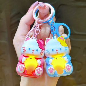 A Hand Holding Two Different Colored Lightup Cat Keychain with a Yellow Fish - Tinyminymo