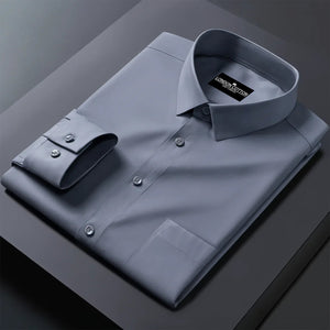 Folded gray dress shirt with a brand label on a dark surface