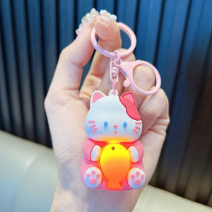 A Hand Holding a Pink Lightup Cat Keychain with a Yellow Fish - Tinyminymo