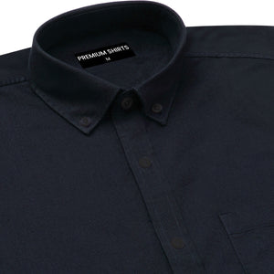 Close-up of a dark blue shirt with a collar and label on a white background