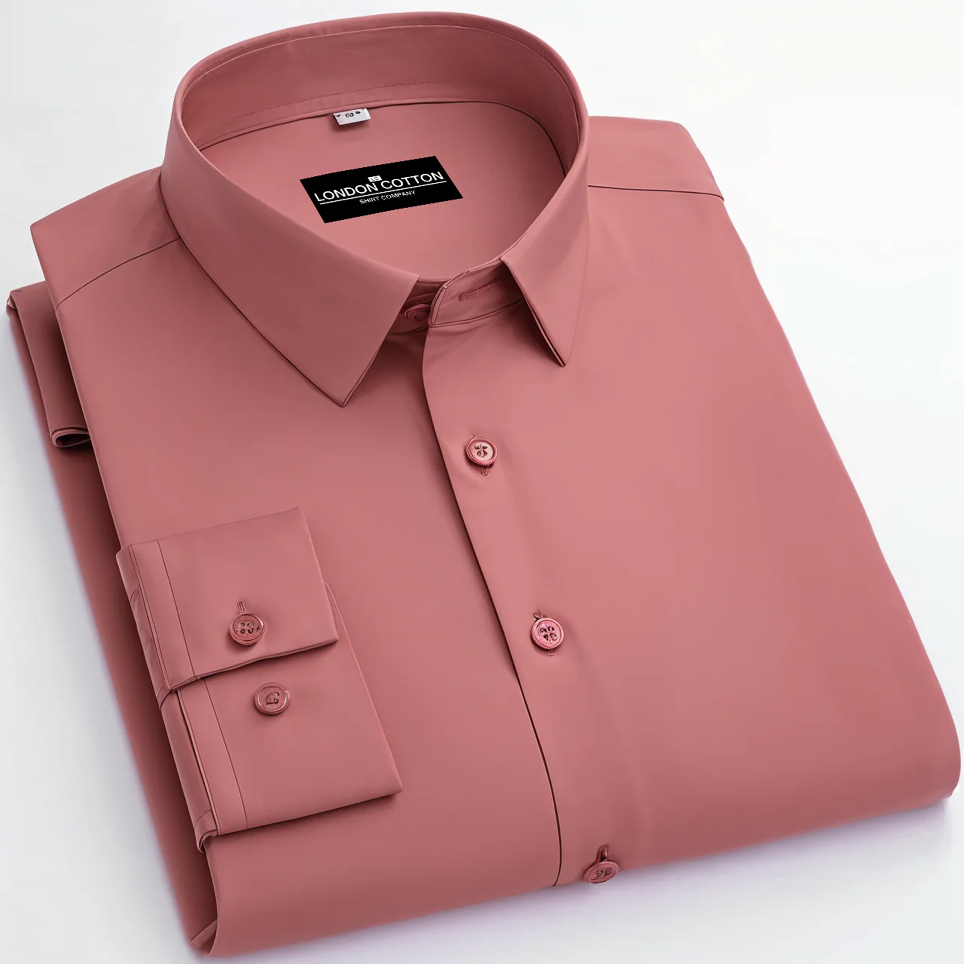 Folded pink shirt with a visible brand label on a white background